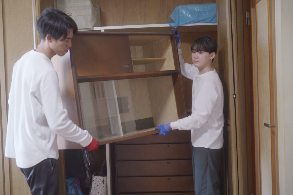 2人で家具を支えて運ぶ様子
